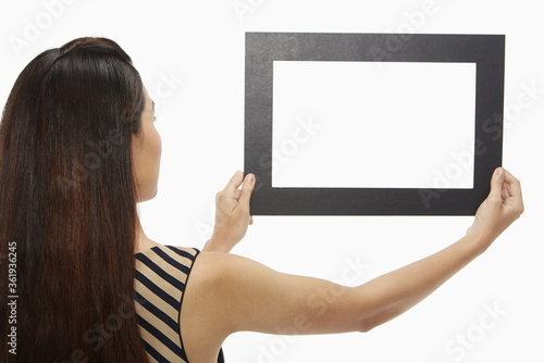 Woman holding up a black frame