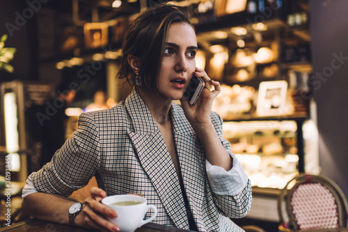 Young woman talking on smartphone in cafe © GalakticDreamer