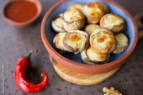 Baked juicy mushrooms with suluguni in a plate close-up. Georgian cuisine