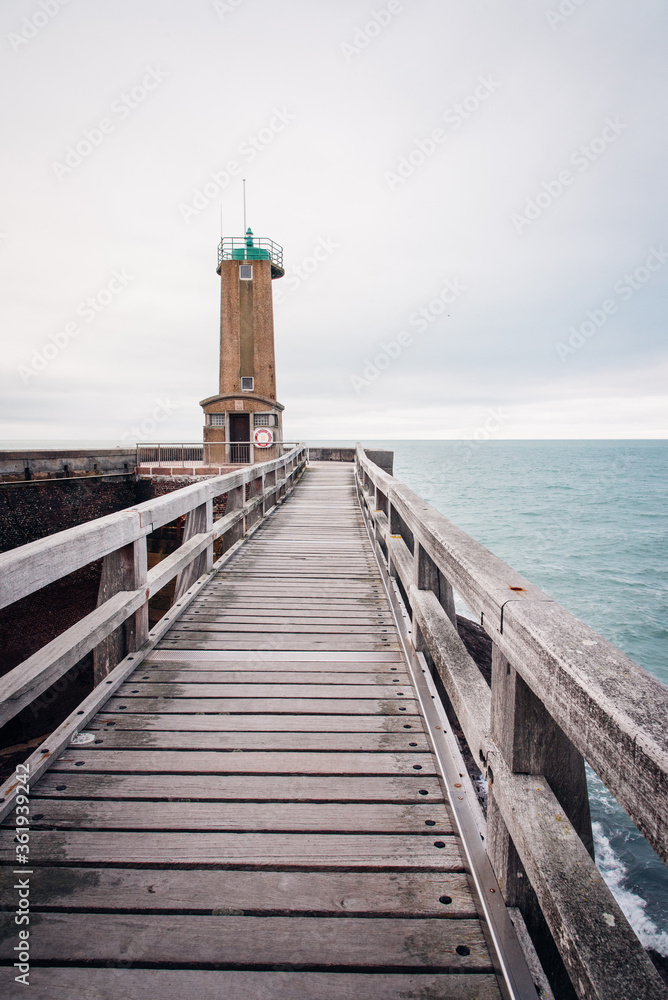 Le phare de Fécamp. Un phare au bord de l'océan. Un ponton menant à un phare.