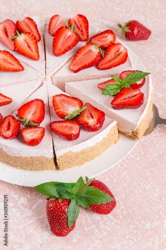 Sweet breakfast, delicious cheesecake with fresh strawberries and mint, homemade recipe without baking, on a pink stone table. Copy space.