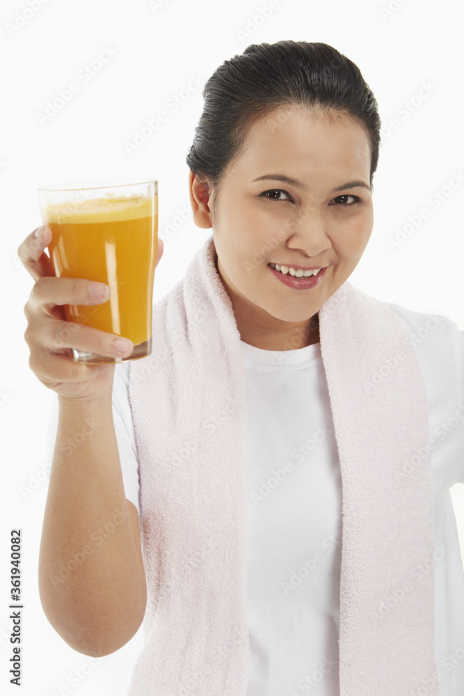 Cheerful woman holding up a glass of orange juice