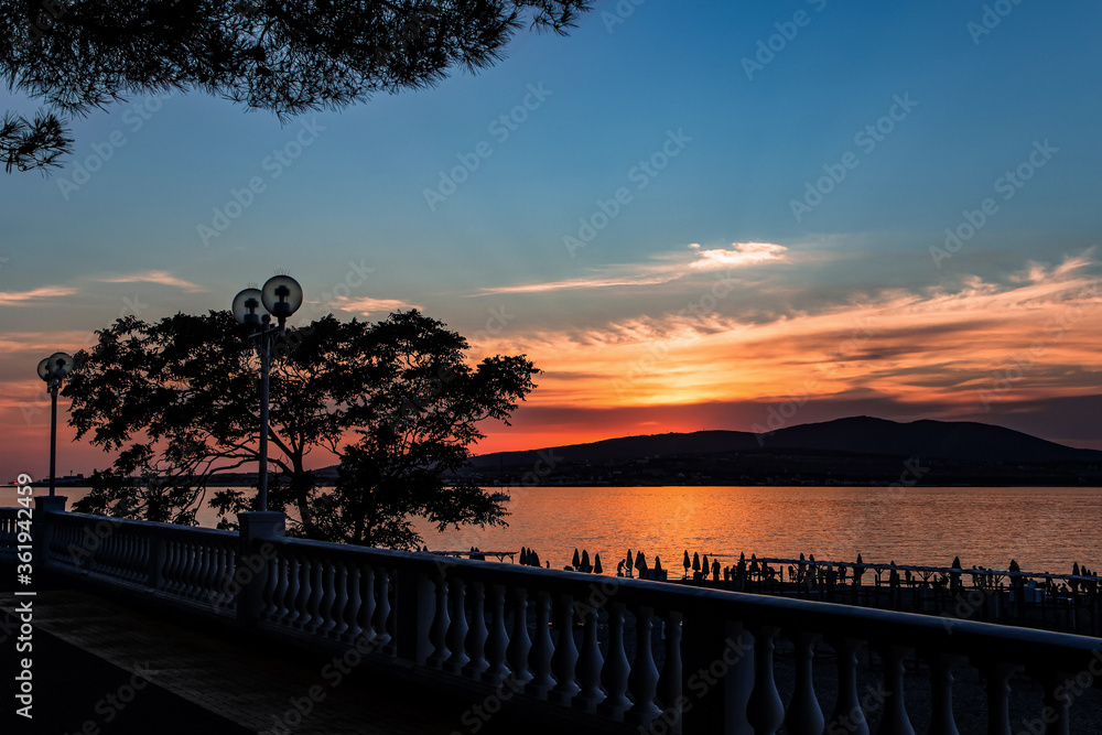 sunset over the mountains and sea, view from the embankment of the resort city of Gelendzhik