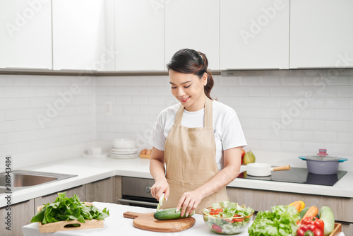 cook Woman cuts vegetables in the kitchen