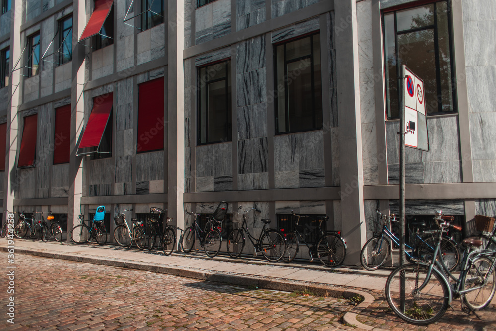Bicycles near facade of building and walkway in Copenhagen, Denmark