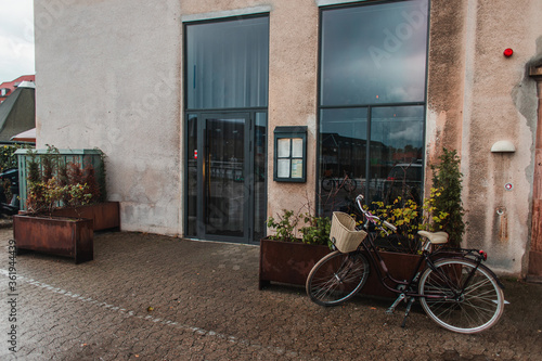 Bicycle near flowerpots and facade of building in Copenhagen, Denmark