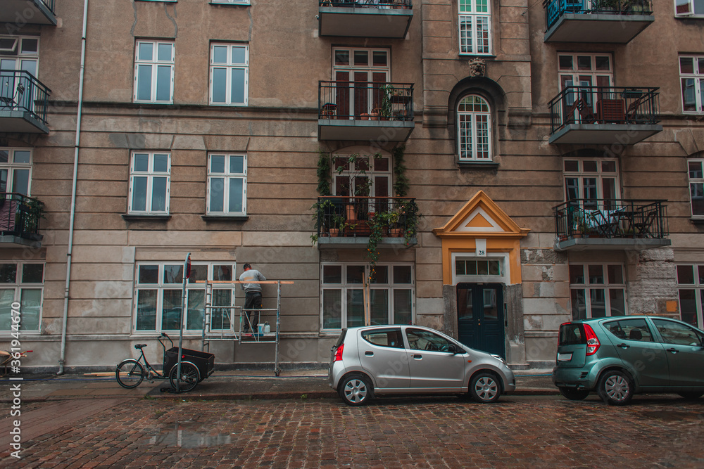 Cars on road near facade of building on urban street in Copenhagen, Denmark