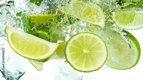 Lime Slices with ice cubes falling deeply under water