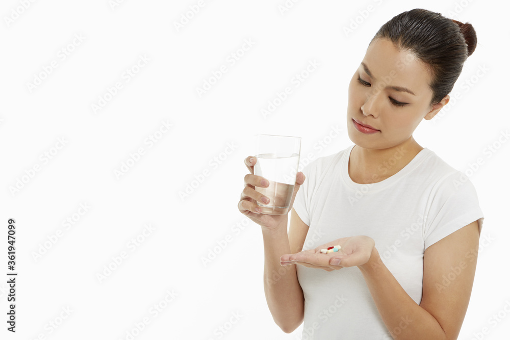 Woman with a glass of water and pills Woman with a glass of water and pills