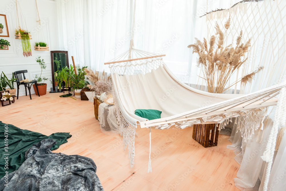 The light photo studio with hammock and big window in beige tones