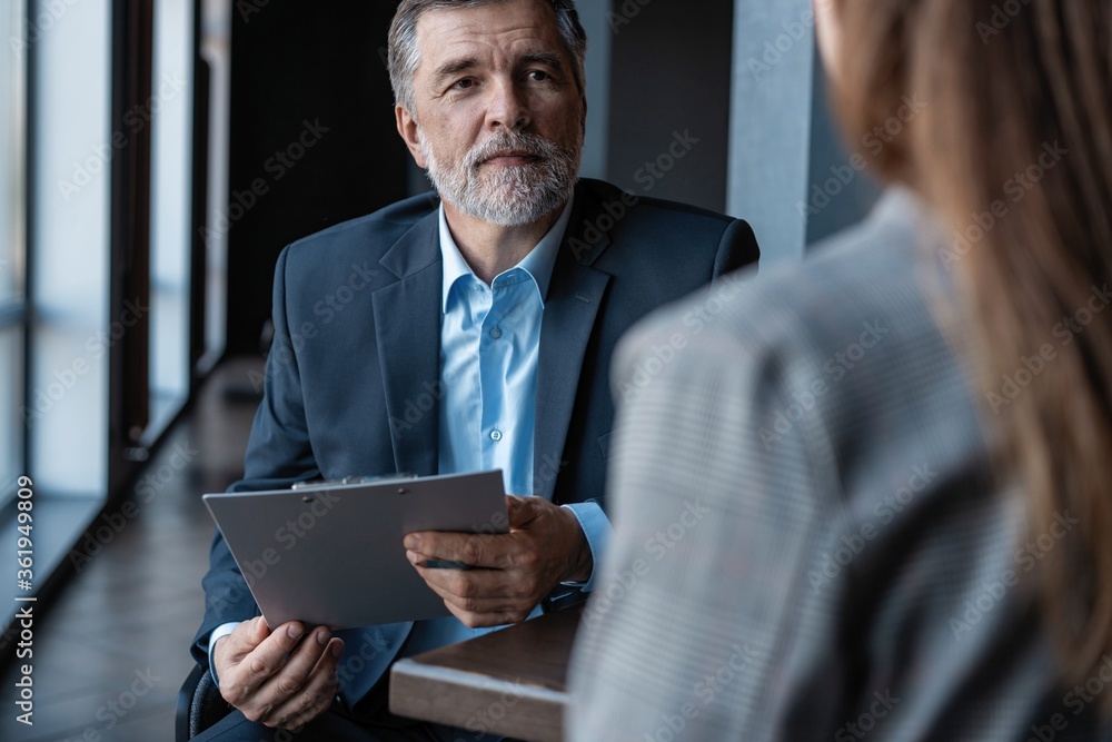 Image of mature businessman interviewing female. Image of mature businessman interviewing female.