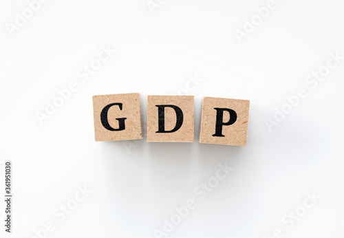 A wooden block with the word GDP written on it on a white background