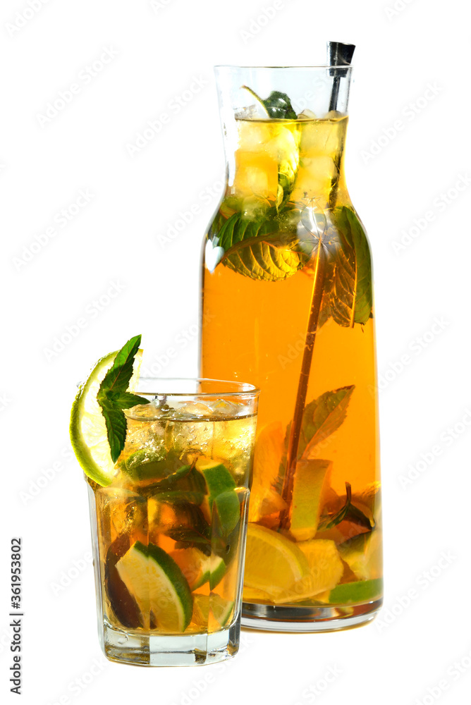 Mint tea with limes in a glass and a full jug on a white background Mint tea with limes in a glass and a full jug on a white background