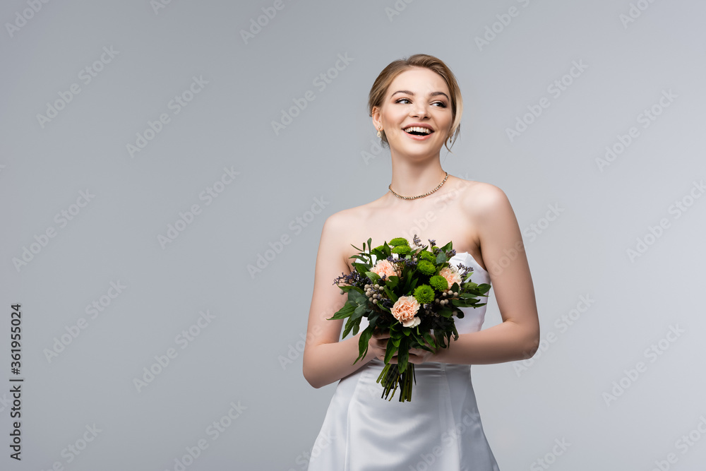 positive girl in white dress holding wedding flowers isolated on grey positive girl in white dress holding wedding flowers isolated on grey