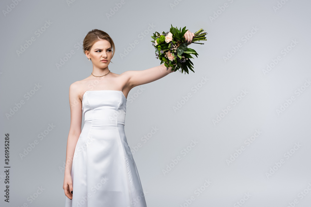 displeased bride in white dress looking at wedding flowers isolated on grey displeased bride in white dress looking at wedding flowers isolated on grey
