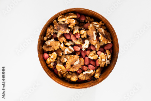 Mix of nuts in a wooden bowl on a white background