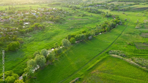 Aerial view photography of the Ukrainian countryside landscape with meadows from high. Farmland and green fields of Ukraine. Natural foliage background.