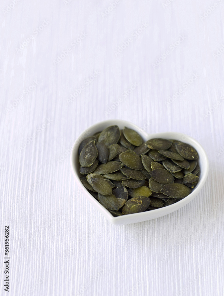 Pumpkin seeds in a heart-shaped bowl Pumpkin seeds in a heart-shaped bowl