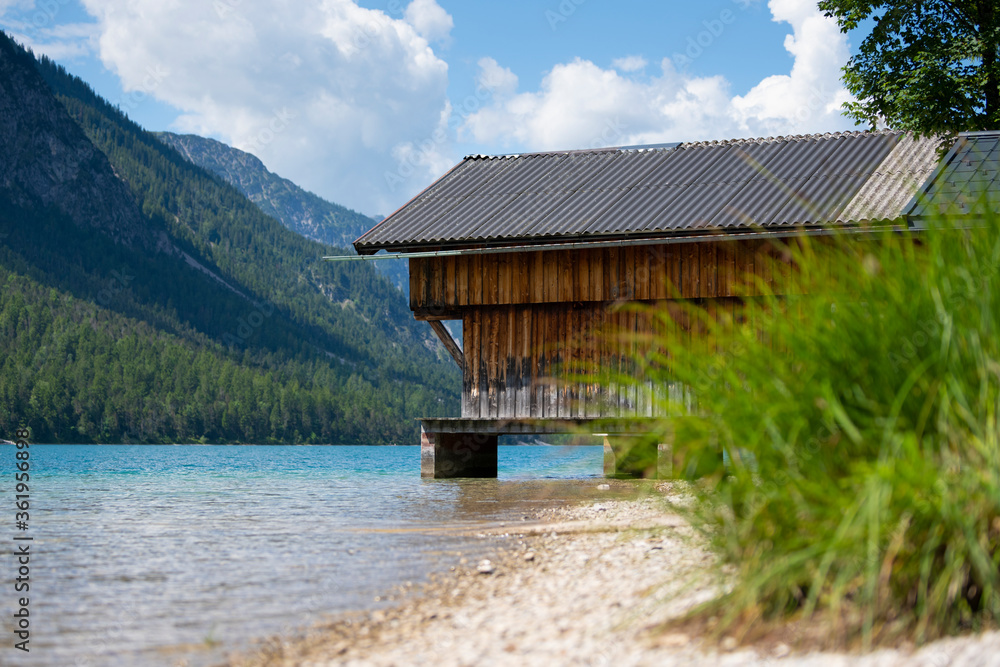 wooden boathouse at waterfront of alpine lake plansee in austria europe