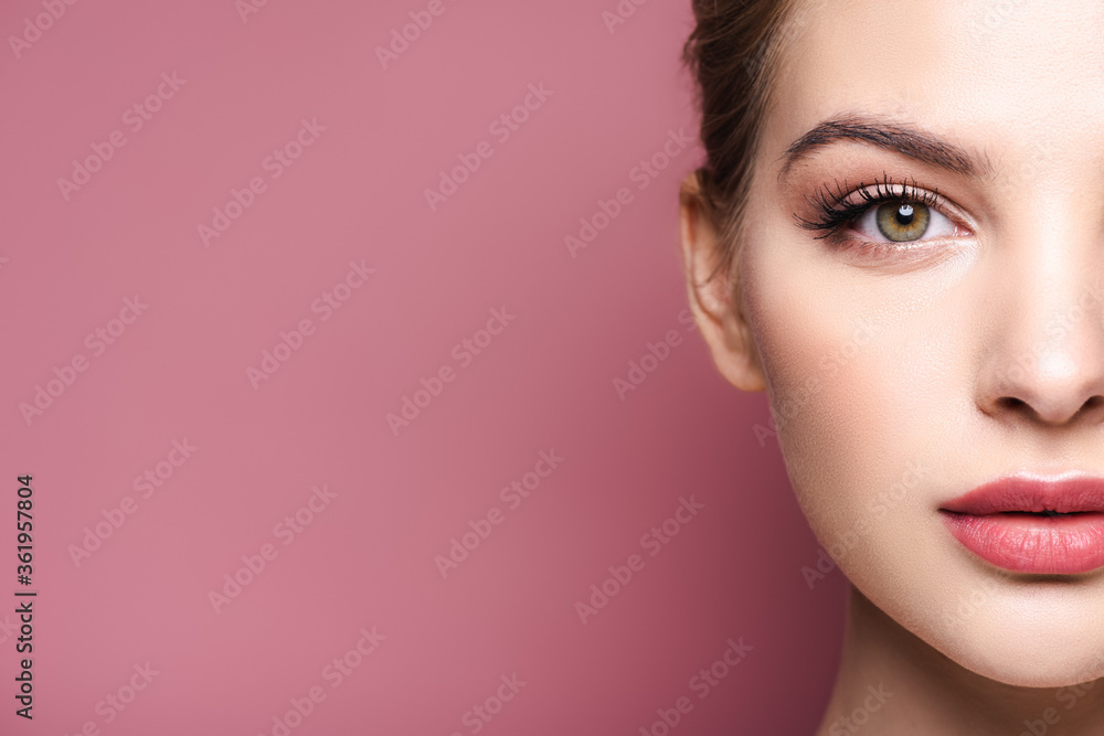 Naklejka premium cropped view of young woman looking at camera isolated on pink