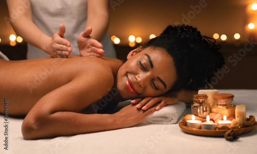 Black woman getting classic body massage at spa