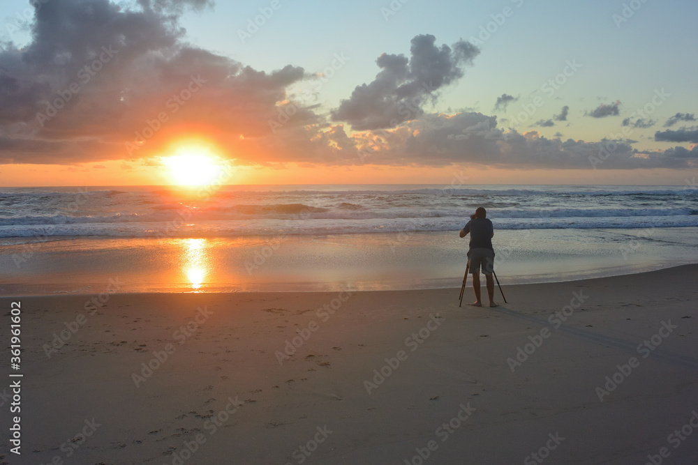 Photographer capturing beach sunrise