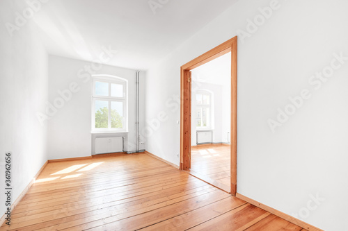empty room in renovated apartment flat with wooden boardfloor and white walls
