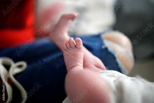 Feet of a newborn baby. Legs on a blue background. Baby feet  lifestyle family photoshoot. 