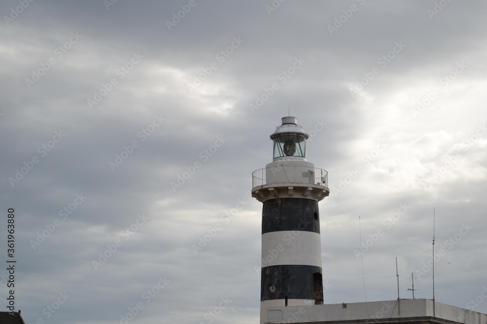 A lighthouse of Calamosca, Cagliari, Italy in grey cloudy sky  