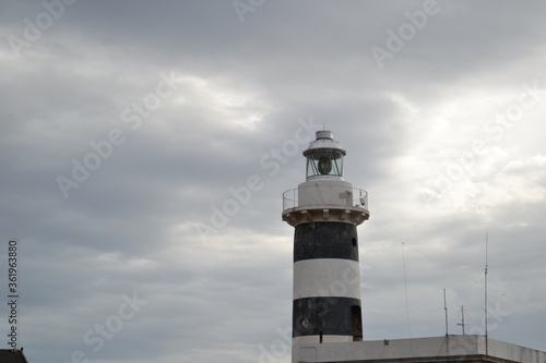 A lighthouse of Calamosca, Cagliari, Italy in grey cloudy sky 