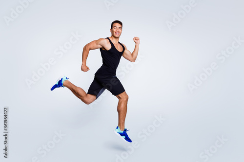 Full length body size view of nice attractive strong sportive muscular cheerful cheery proud guy jumping running goal cup champion sprinter isolated over light gray pastel color background © deagreez