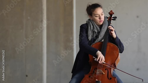 Mujer tocando con pasión el violonchelo al aire libre