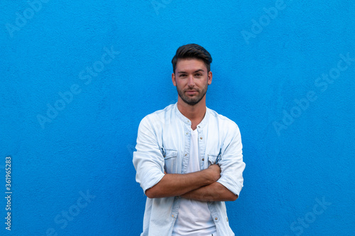 man posing outdoors on a blue background
