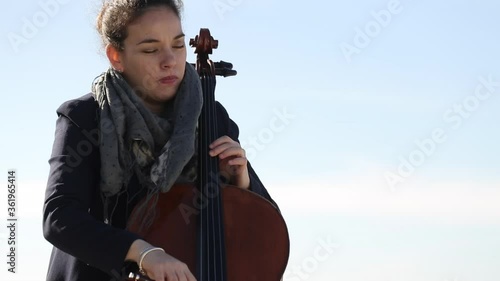 Mujer tocando con pasión el violonchelo al aire libre