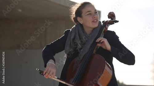 Mujer tocando con pasión el violonchelo al aire libre