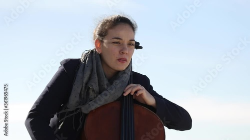 Mujer tocando con pasión el violonchelo al aire libre