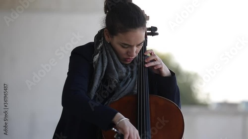 Mujer tocando con pasión el violonchelo al aire libre