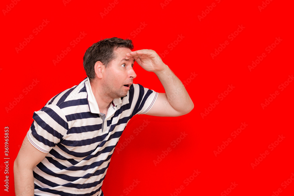 Surprised enthusiastic man in a striped t shirt look to the side palm of his hand at the head Surprised enthusiastic man in a striped t shirt look to the side palm of his hand at the head