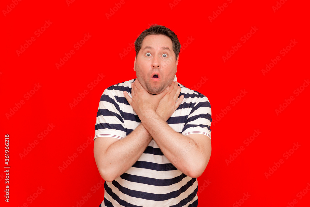 Closeup of european male touching painful neck as stretching concept isolated on red Closeup of european male touching painful neck as stretching concept isolated on red