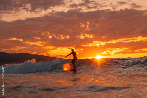 Surfing silhouette at sunset.