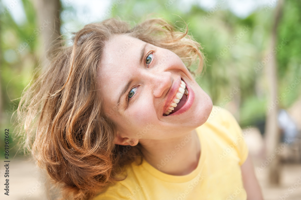 Natural portrait of happy smiling curly 25 years old girl without make-up. Healthy skin. Summer happiness