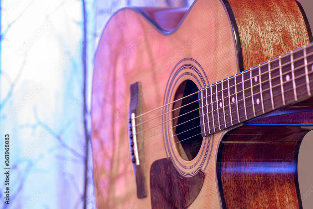 Fototapeta premium Acoustic guitar on a beautiful colored background. The concept of stringed instruments.