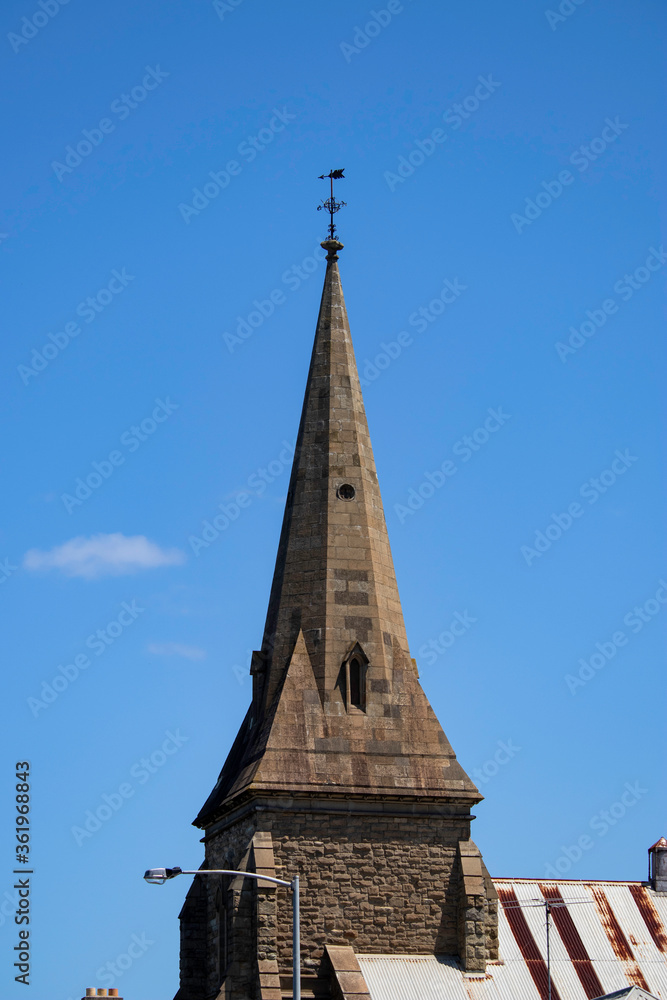 Church steeple with a single cloud in the blue sky