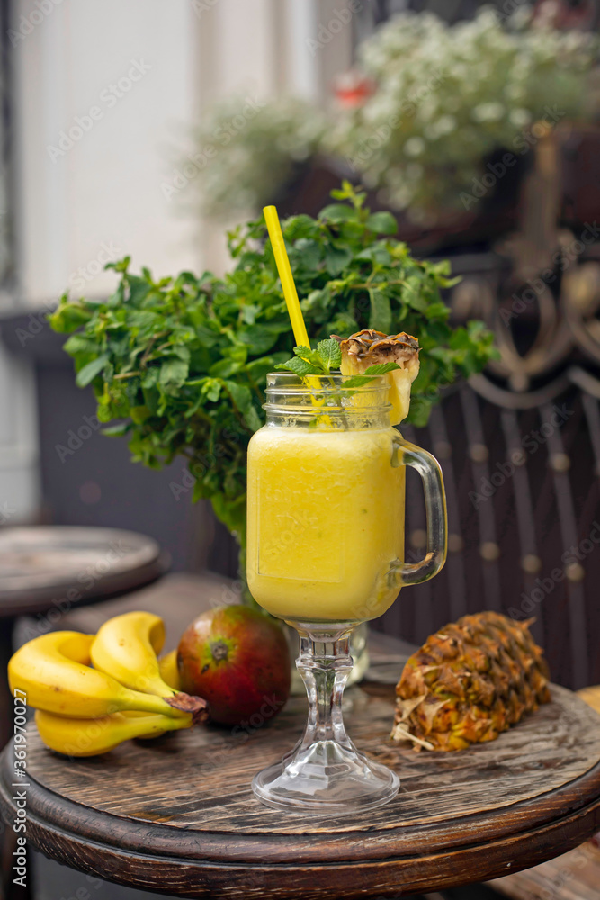 Fototapeta premium Cool smoothie with pineapple, mango, banana and mint on wooden background