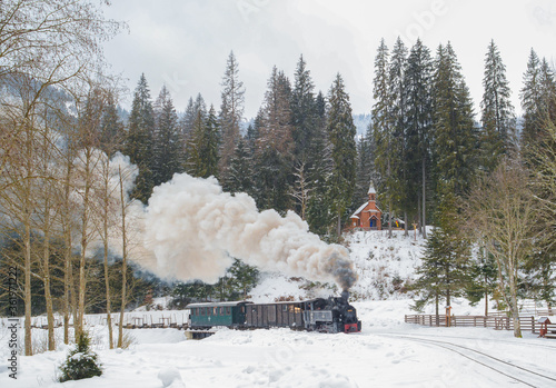 Mocanita Maramures from Romania in a winter day with a beautiful church into the mountains 