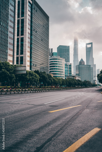 The traffic on central avenue  with modern skyscrapers in the back  in Shanghai  China  shot at sunset  on a cloudy day.