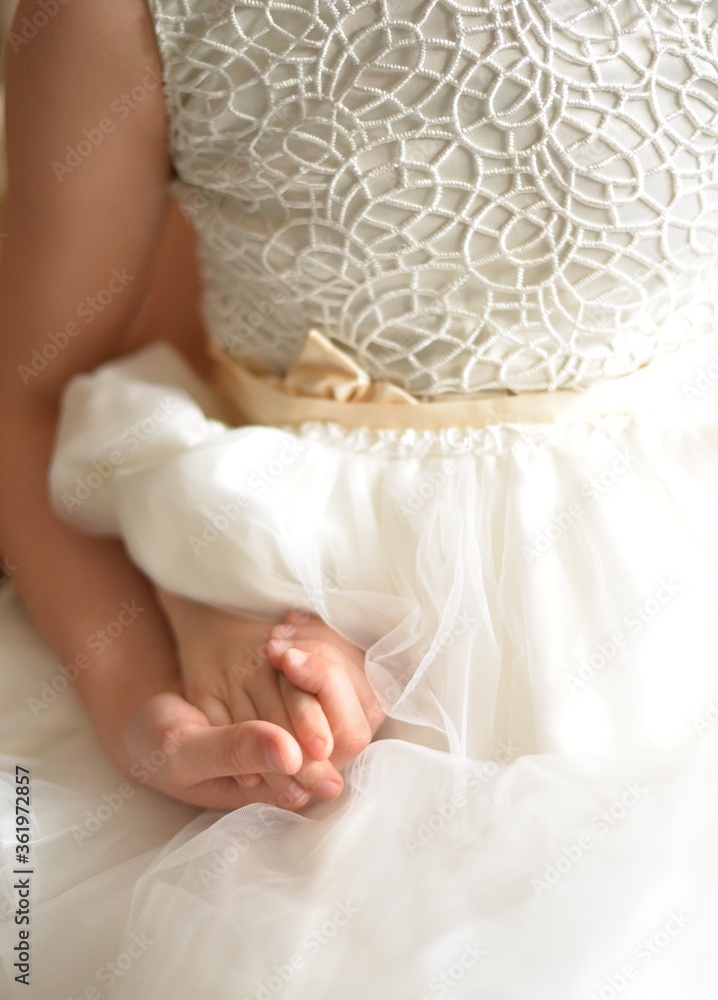 Children's hands holding each other on a white holiday dress background Children's hands holding each other on a white holiday dress background