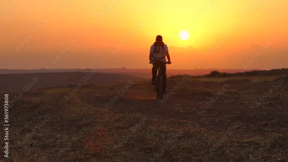 Man Riding Bicycle During Sunset, Outdoors Activity, Sport ,Summer Field - slow motion Man Riding Bicycle During Sunset, Outdoors Activity, Sport ,Summer Field - slow motion