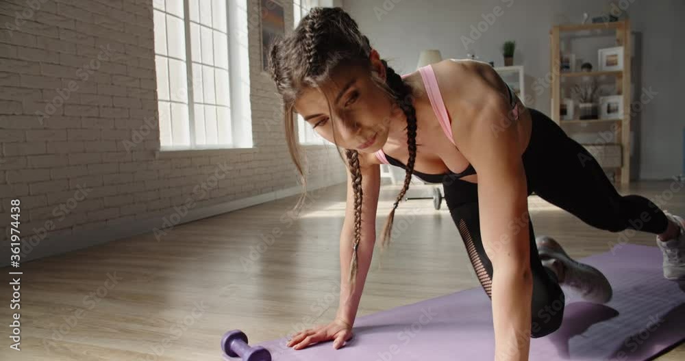 Young fit slimming sportswoman does running plank as part of cross fit training. Motivated female athlete working out at home, achieving her goals - sports, healthy lifestyle concept 4k footage