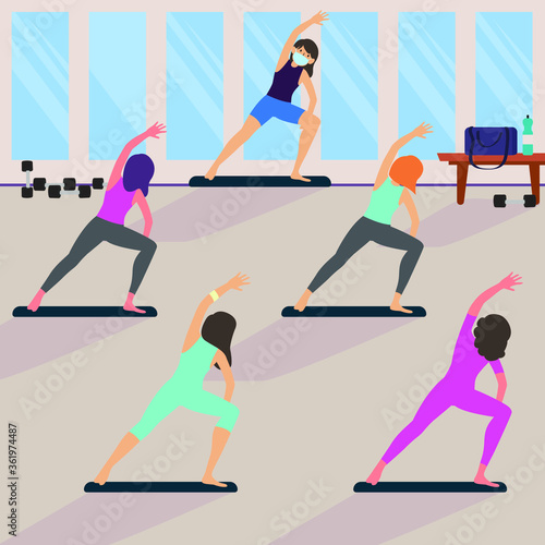 Womans are keeping their distance while doing yoga in yoga class